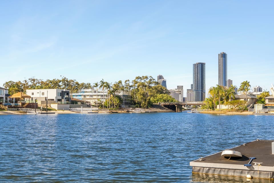 Look towards the Broadbeach skyline from the private jetty, where the wide canal stretches towards the city beyond, bringing peaceful waterfront scenery and urban horizons into one sweeping outlook.