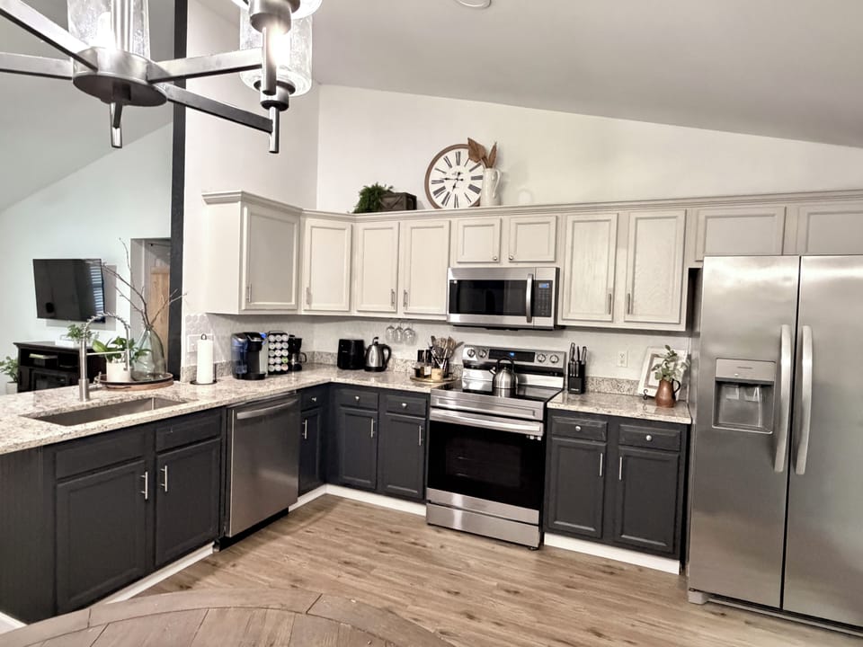Fully equipped kitchen with stainless appliances, coffee station and island.