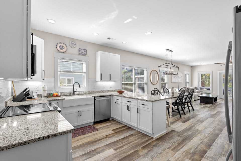 Picture yourself cooking in this bright, open kitchen where gleaming granite counters and modern appliances make meal prep a breeze, while your family gathers around the dining table just steps away.
