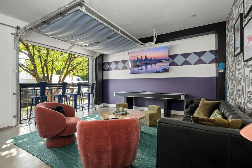 Stylish game lounge with shuffleboard and indoor-outdoor patio vibes