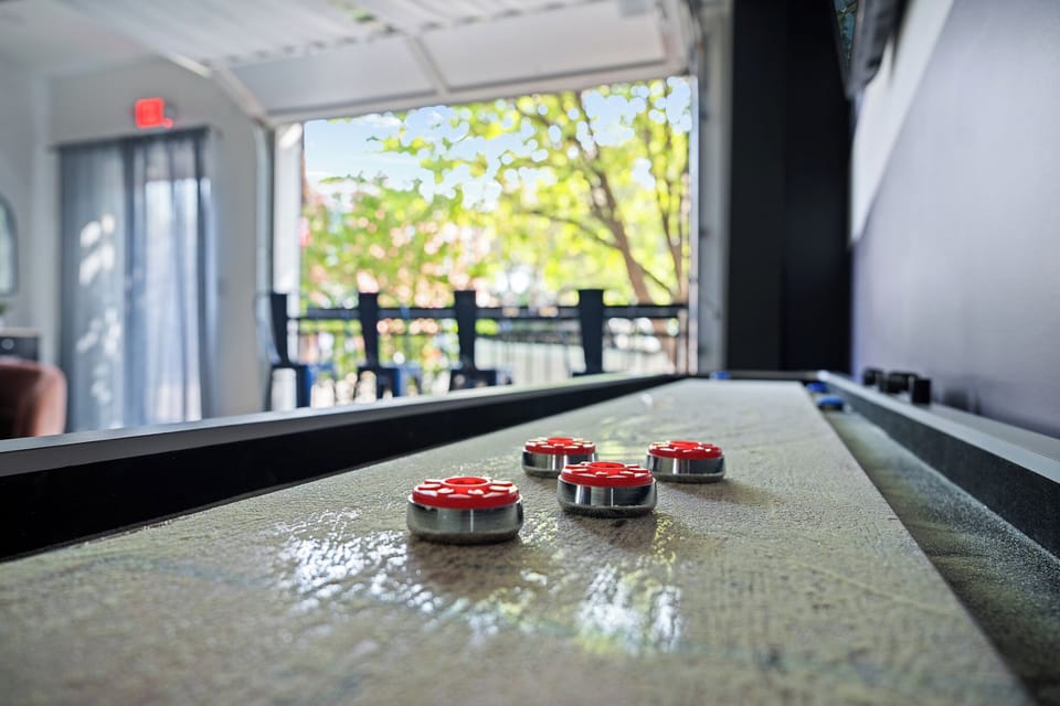 Game Room: Shuffleboard fun with a bright open-air patio view!