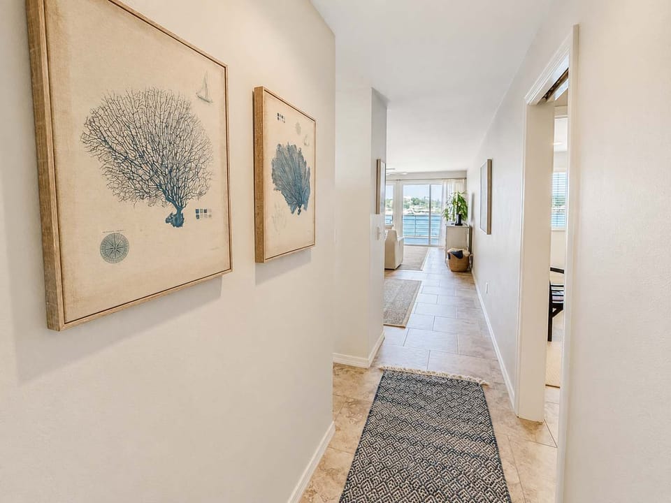 Entry hallway with bedroom, bunkroom, laundry & bathroom to the right and kitchen to the left. 