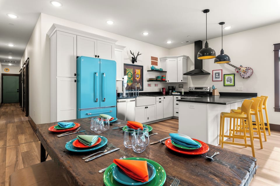Colorful designer kitchen with large dining table and sunny breakfast bar