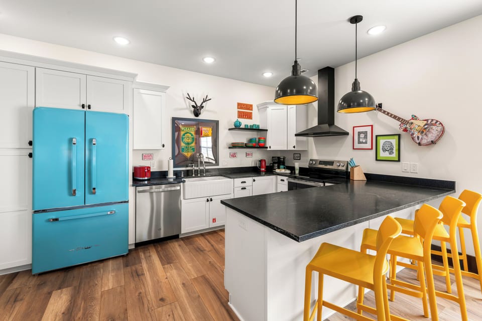 Colorful modern kitchen with island seating and a retro blue fridge