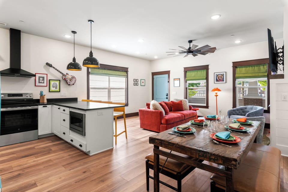 Bright open living space with modern kitchen, dining table, and cozy seating