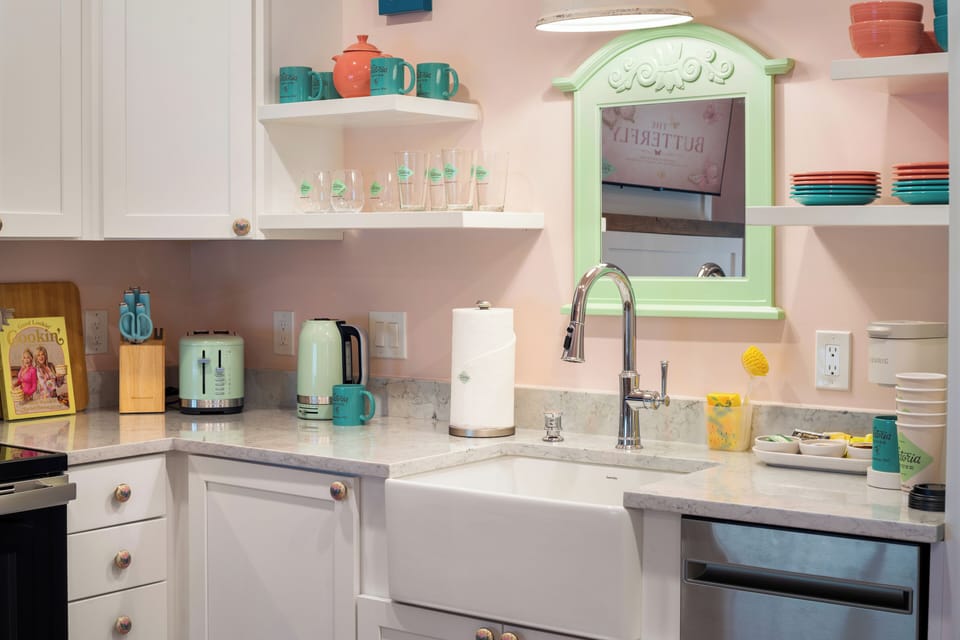 Charming pastel kitchen with farmhouse sink and cheerful open shelving
