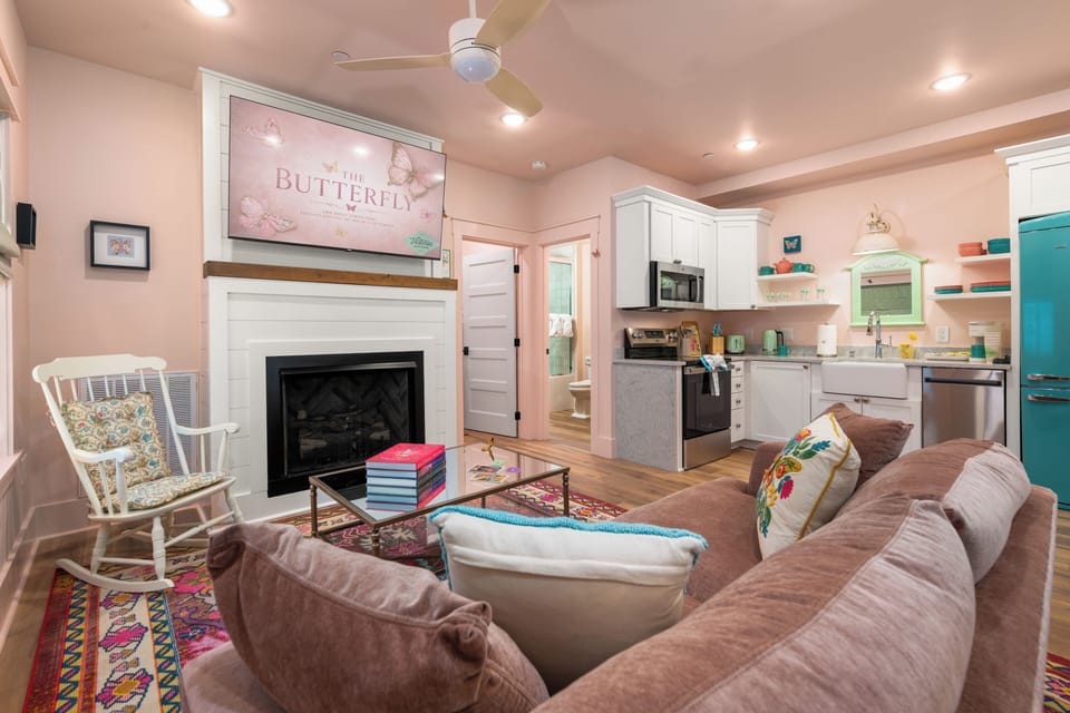 Cozy pastel living room with fireplace and charming full kitchen