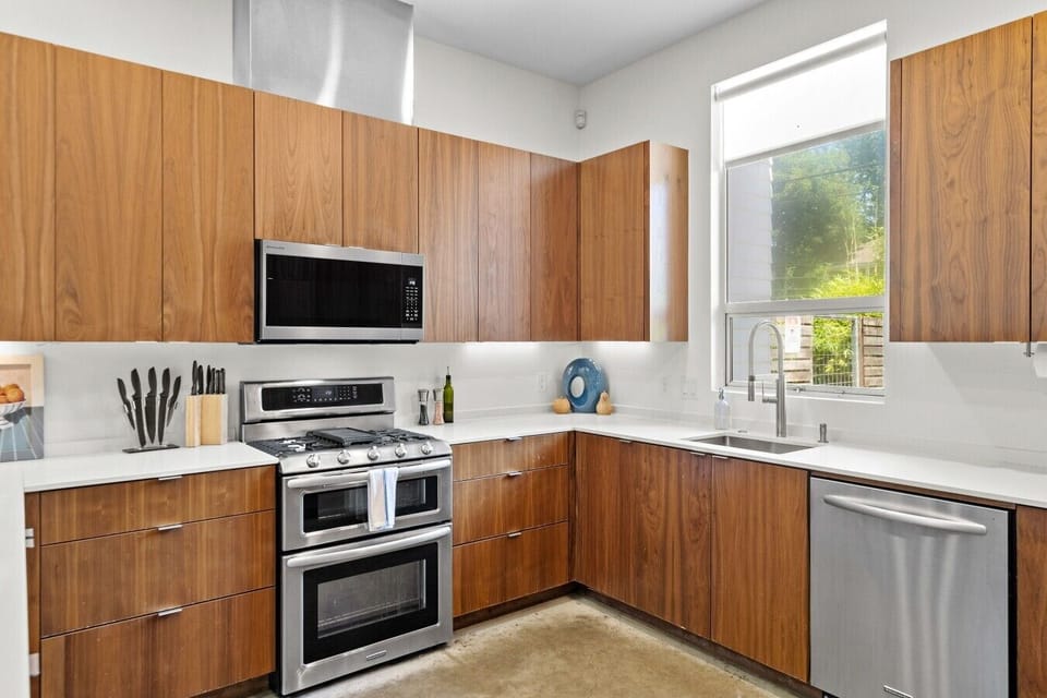 Prep group dinners on the gas range with double oven, plus a garden view above the sink.