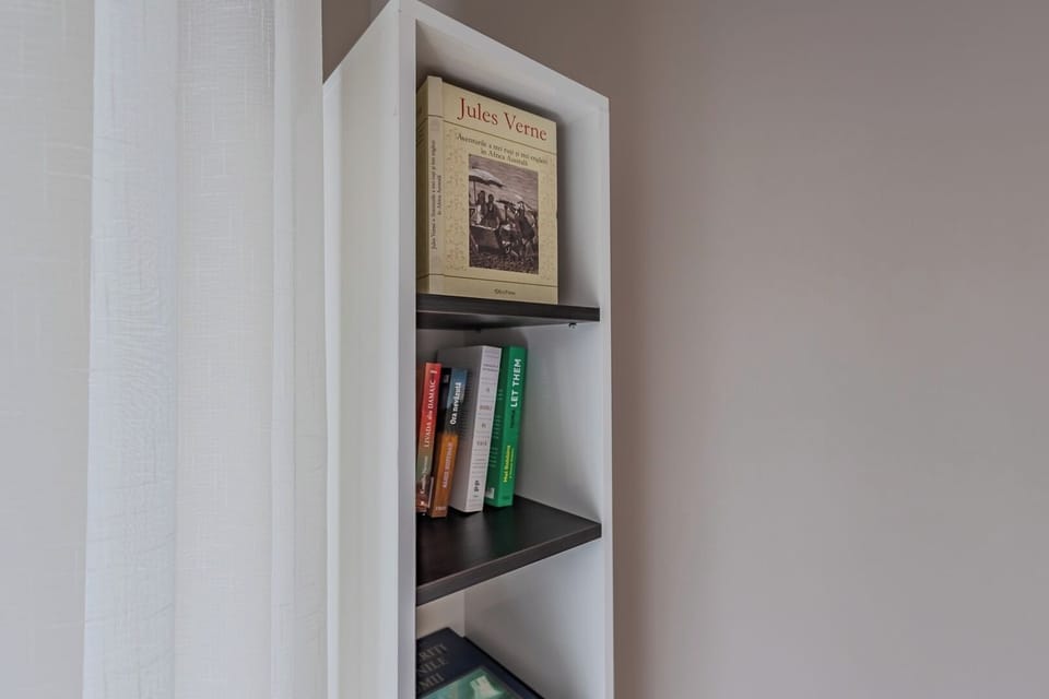 Built-in bookshelf with a curated selection of books — a thoughtful detail for guests who want to unwind after a day exploring Brasov. White Feather by Bianca, Str. Albatrosului, Avantgarden, Brasov.