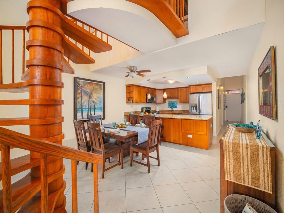 Dining area and updated kitchen with spiral stairs to lofted bedroom