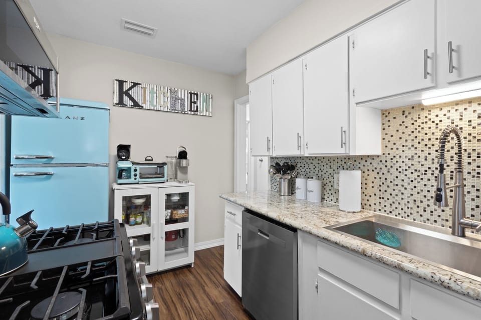 Whip up beach-day meals in this bright kitchen, complete with a retro fridge, gas range, and a dedicated coffee station for slow mornings.