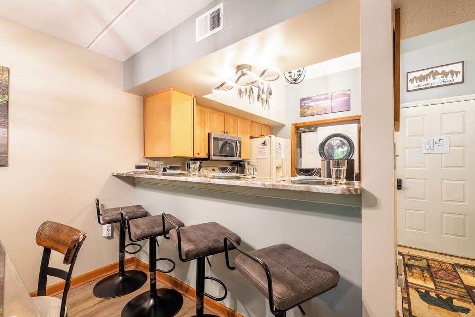 Step into your fully equipped kitchen, where morning coffee at the breakfast bar feels effortless. The open design flows naturally, inviting you to unwind after a day of adventure.