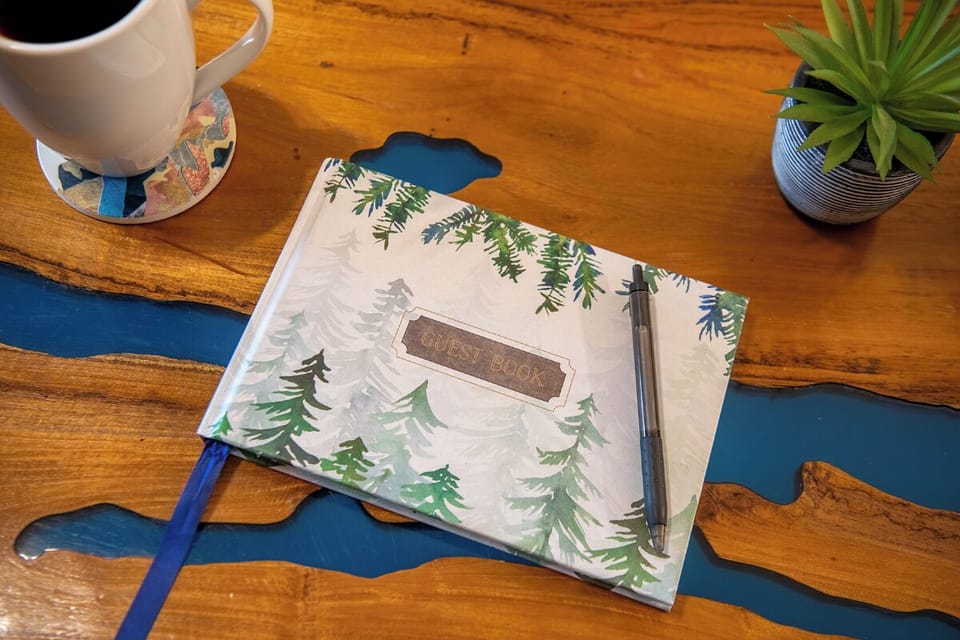Start your mornings at the vintage wood table, where  thoughtful touches await you. A guest book invites your reflections while the cheerful greenery adds a welcoming accent to your coffee ritual.