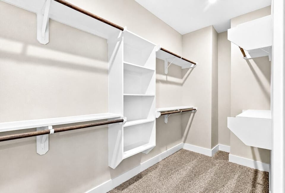 Spacious Walk-in Closet: Ample storage with stylish wood accents for your fashion finds!