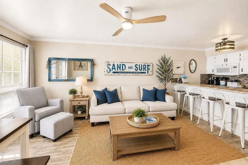 Bright coastal living room with breakfast bar and open-concept kitchen