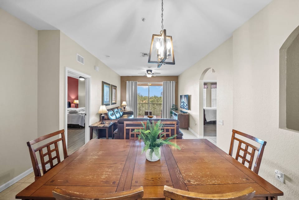 Join loved ones at the rustic wooden dining table, enjoying meals under a stylish pendant light. The open layout fosters warmth and conversation, while large windows showcase lovely views, creating an inviting atmosphere.