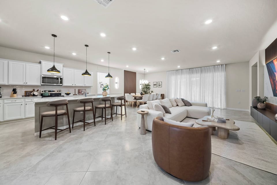 Relax in comfort and style in this spacious living area, filled with soft gray tones, sleek cabinetry, and a cozy leather chair. The open layout and natural light create an inviting retreat after your adventures.