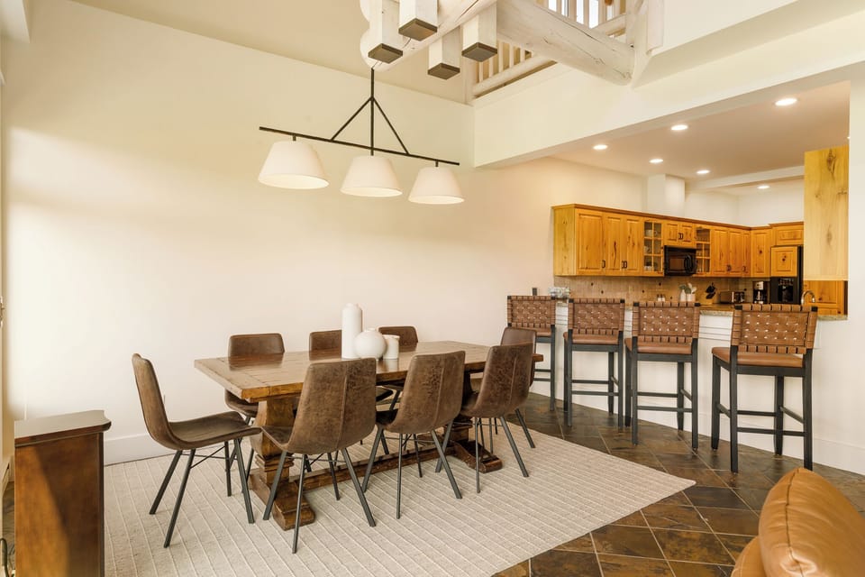 Gather your group around the rustic dining table or perch at the breakfast bar—this open-plan space flows effortlessly, making every meal feel like part of the adventure.