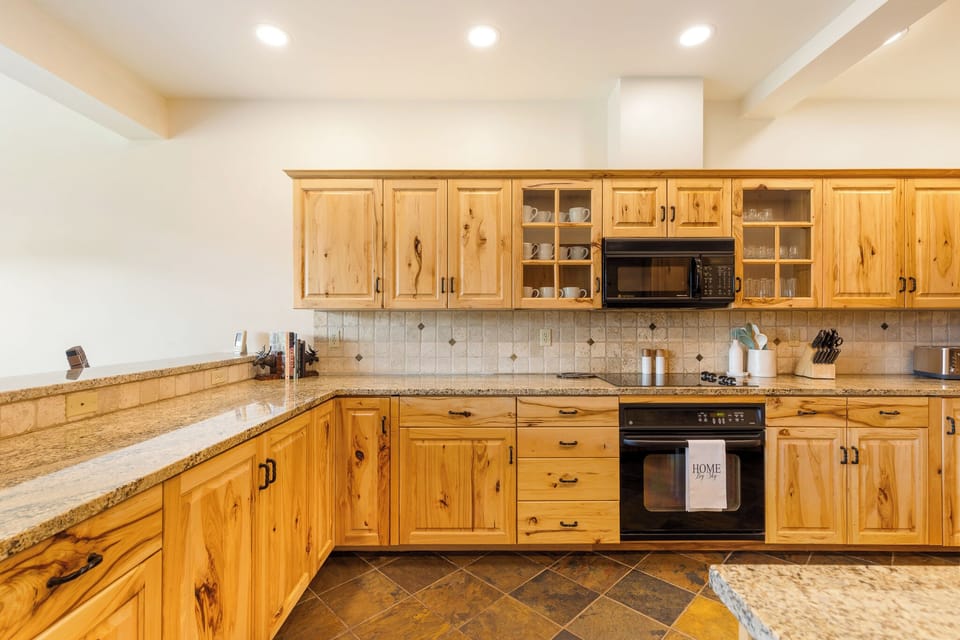 Step into your fully equipped kitchen with warm wood cabinetry, granite countertops, and everything you need to prepare your favorite meals during your stay.