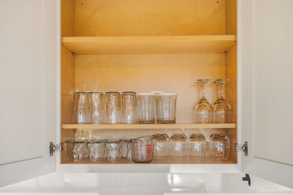 Fully stocked kitchen cabinets with plenty of glasses for all your guests, from water tumblers to wine glasses.