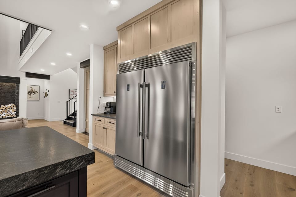 Modern gourmet kitchen with built-in fridge and open-concept design