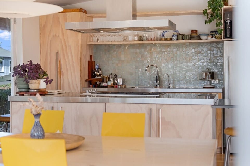 Designer kitchen with warm timber finishes and stainless steel benchtops