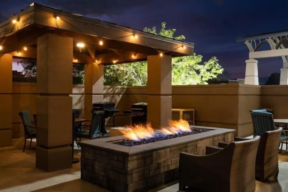 Gather around the stone fire pit under twinkling lights, enjoying warmth and conversation on the outdoor patio