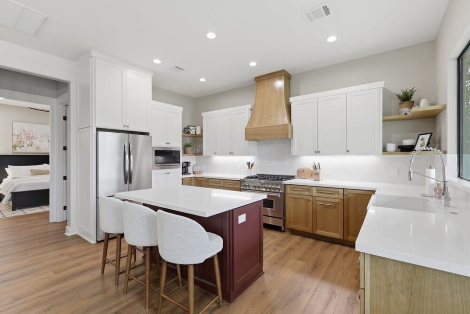 Cook with ease in the fully equipped chef`s kitchen, featuring stainless steel appliances including a gas stove, microwave, dishwasher, and a spacious refrigerator.