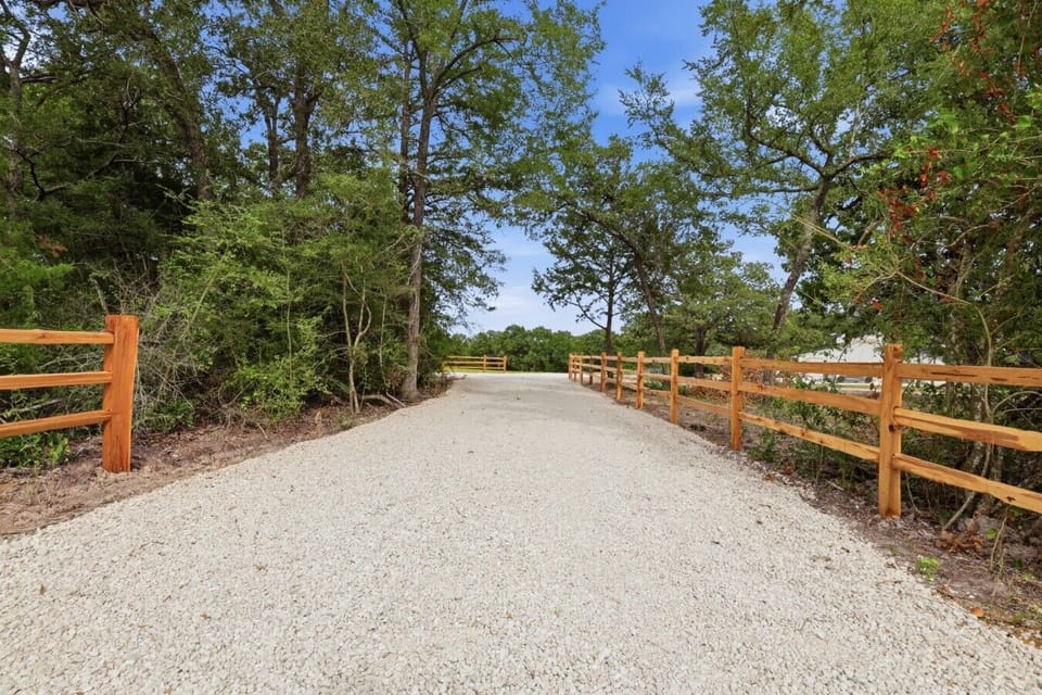 A stone driveway path winds through the front of the property, creating a welcoming approach that leads directly to the home.