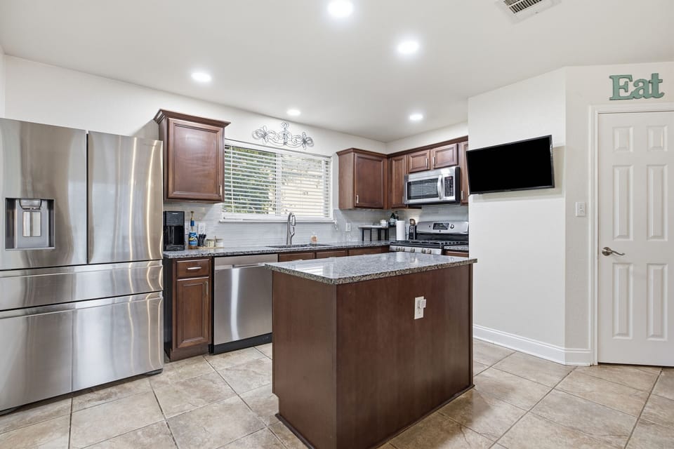 Bright modern kitchen with island, granite counters, and stainless appliances