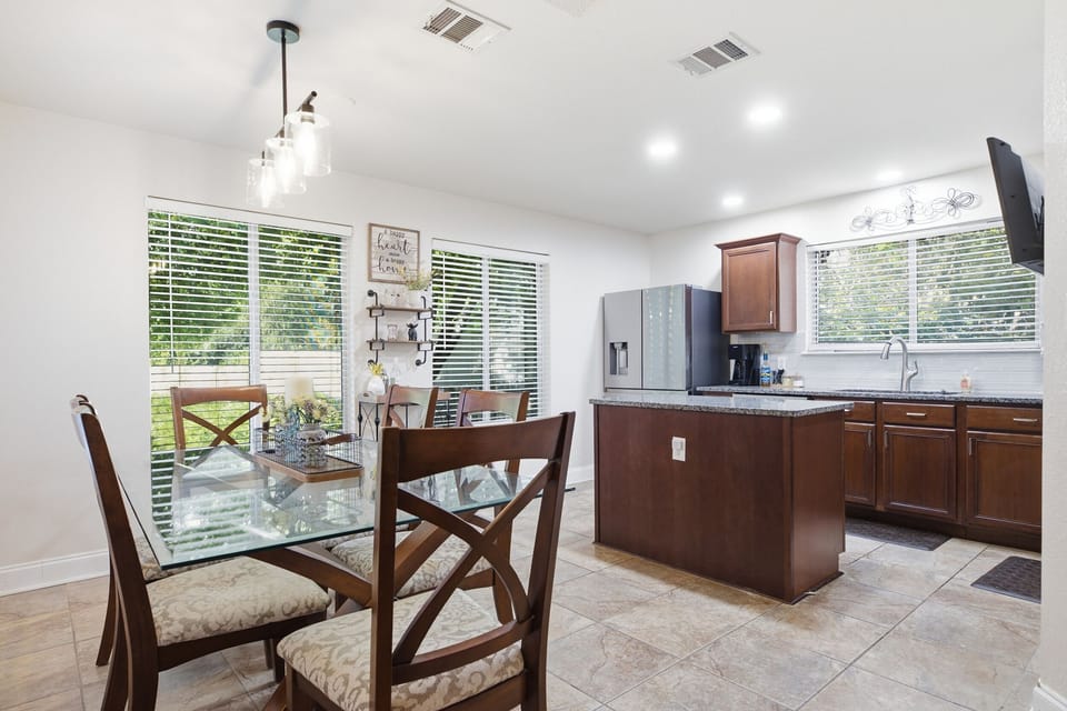 Bright open kitchen and dining area with island and large sunny windows