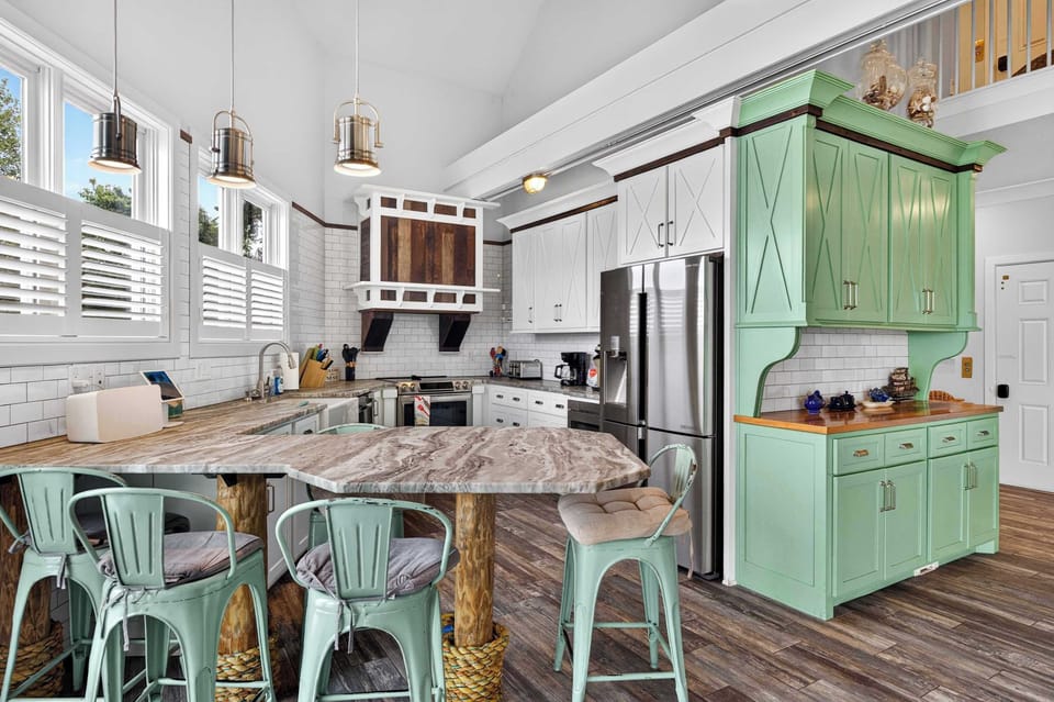 Dining Area: Cook, dine, and gather in this inviting kitchen and dining area, featuring a practical layout, essential appliances, and a cozy coastal atmosphere.