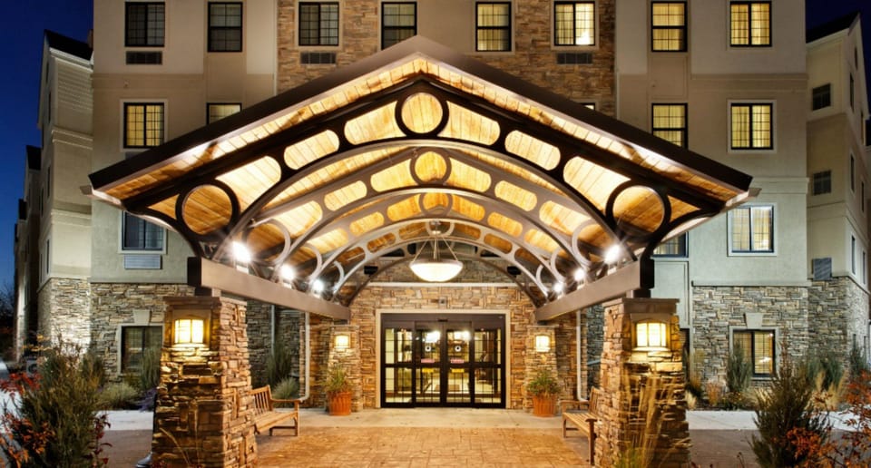Hotel exterior at night with illuminated entrance canopy and signage
