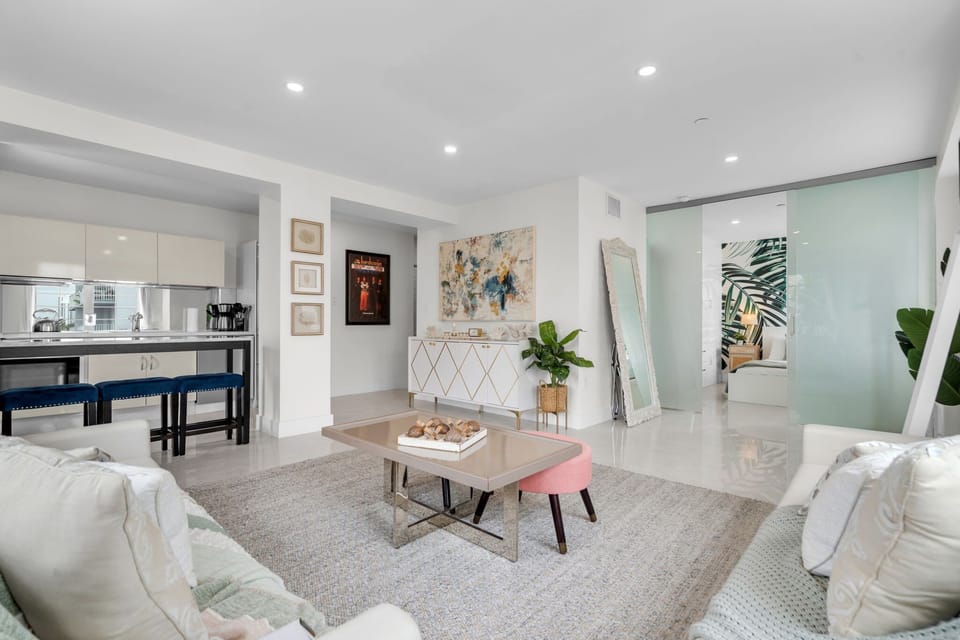 Spacious and stylish living area with curated art, sleek modern finishes, and an effortless flow from lounge to kitchen — the perfect gathering spot to unwind after a day of sun and sand in South Beach.