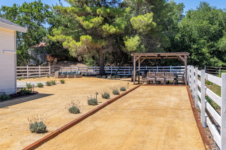 Spacious fenced yard with shaded pergola dining and lounge seating