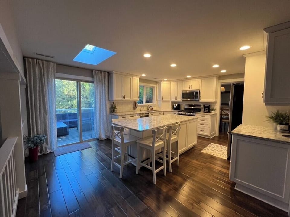 Kitchen and dining with skylight, deck beyond