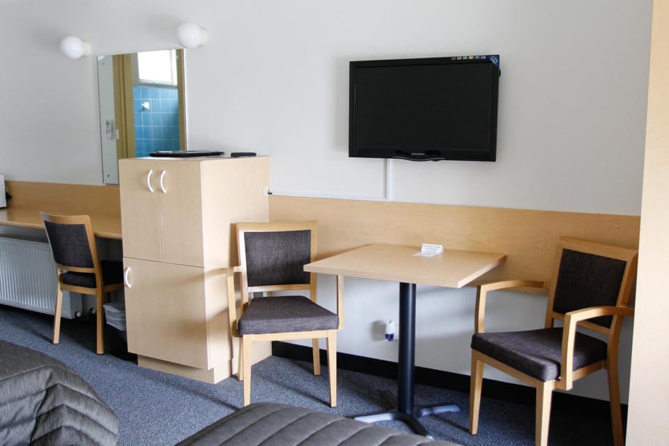 Desk, laptop workspace, blackout drapes, iron/ironing board