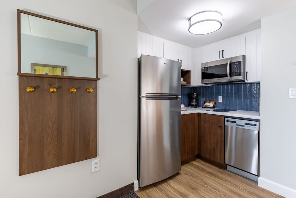 Fully stocked kitchen with stainless steel appliances and wood cabinetry.