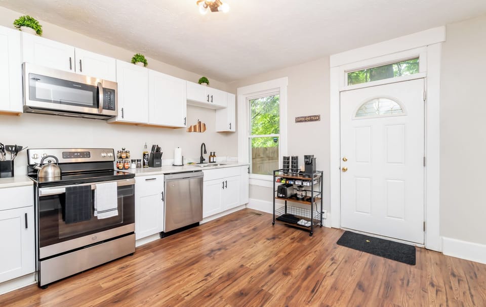 See how much sunlight fills the cooking area from the bright back door window. The stylish black oven towel matches the modern kitchen hardware perfectly.