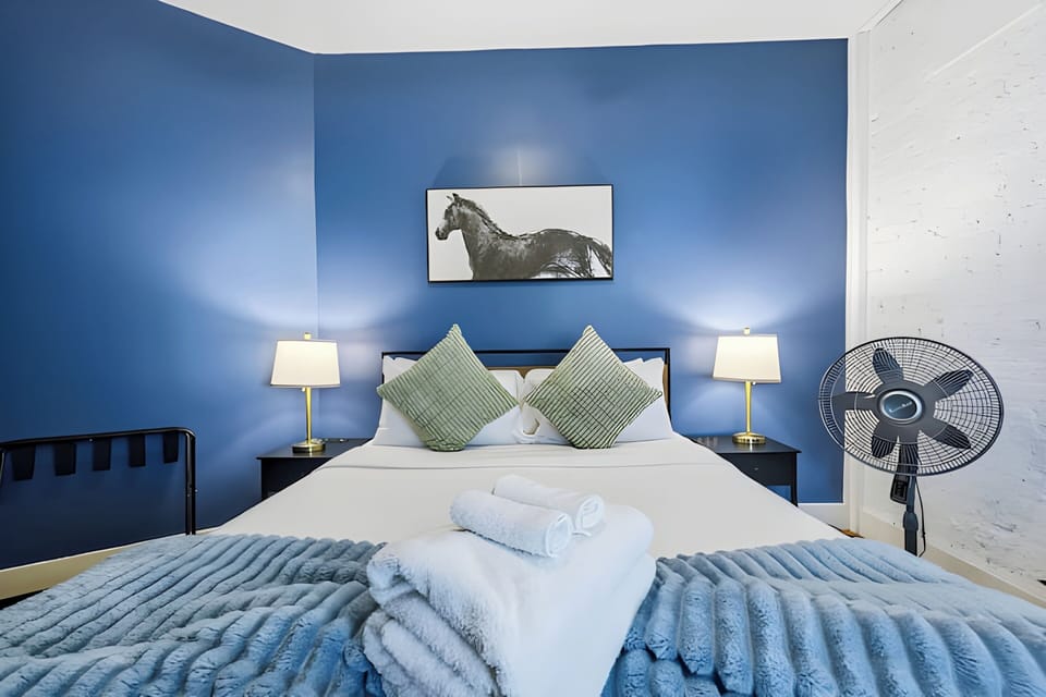 Notice the lovely details like the modern bedside lamps and the cool vintage fan. This blue bedroom is truly a relaxing retreat for any traveler.