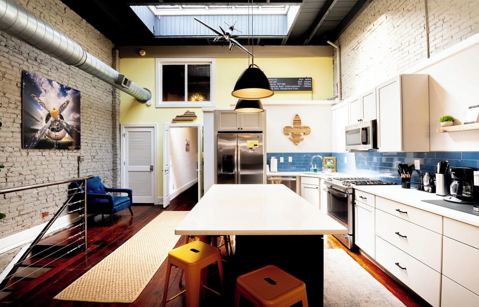 Serve up breakfast on the huge white kitchen island surrounded by sunny yellow stools. You get an amazing view of the entire loft from this central spot.