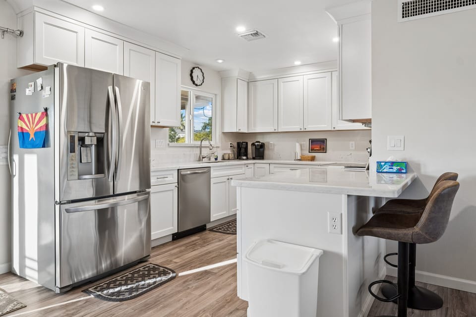 Stainless steel appliances, wine fridge, counter seating for 2, and cooking essentials.