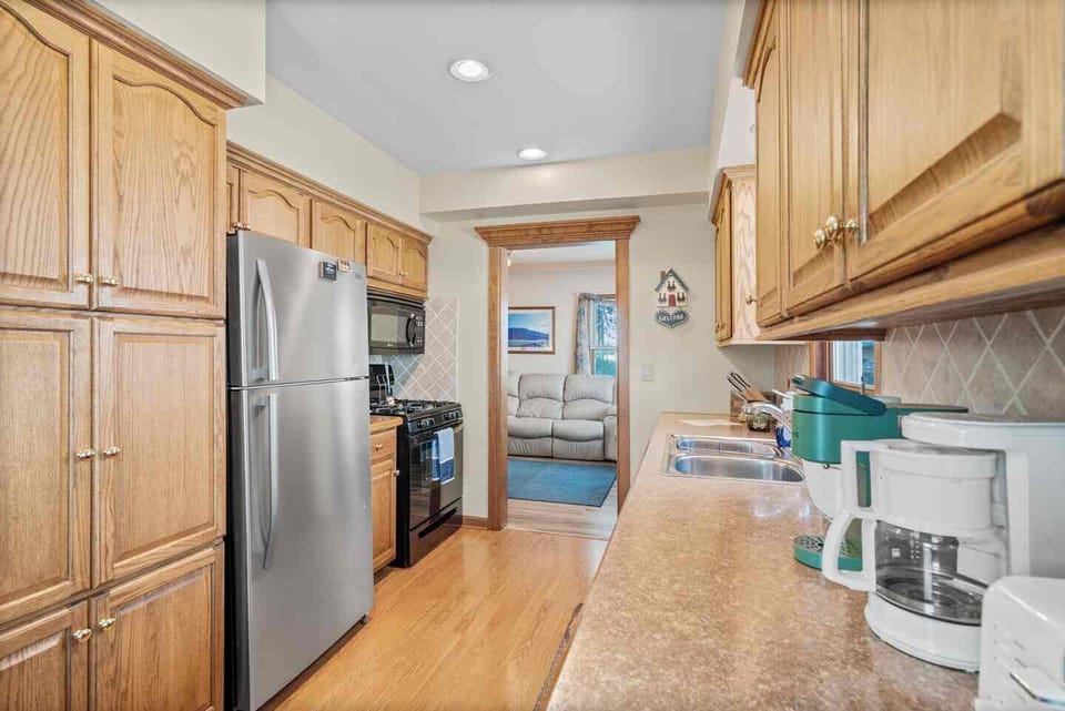 Recently renovated kitchen with appliances, coffee makers, and dishes. 