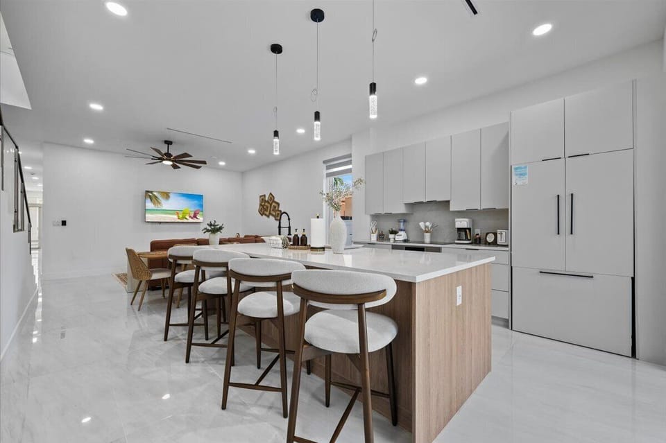 Kitchen island breakfast bar with barstool seating open to living area.