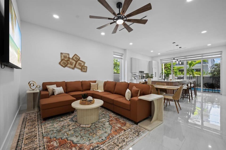 Spacious open-concept living room with sectional sofa and ceiling fan.