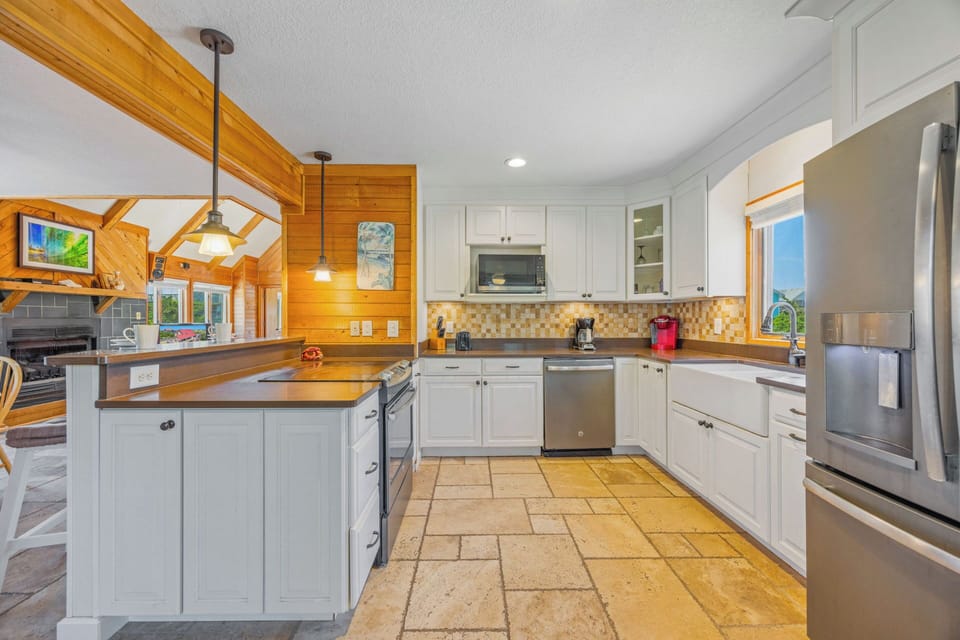 Your fully equipped kitchen blends rustic wood beams with modern stainless-steel appliances, offering plenty of counter space and natural light to inspire your culinary creations.