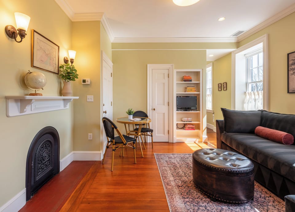 Built-in bookshelf, recessed lighting, and a cozy seating area for reading.