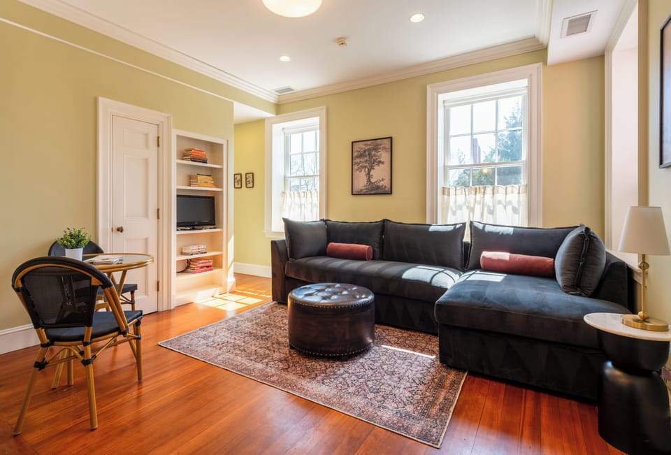 Spacious living room with a plush sectional, chaise lounge, and hardwood floors.