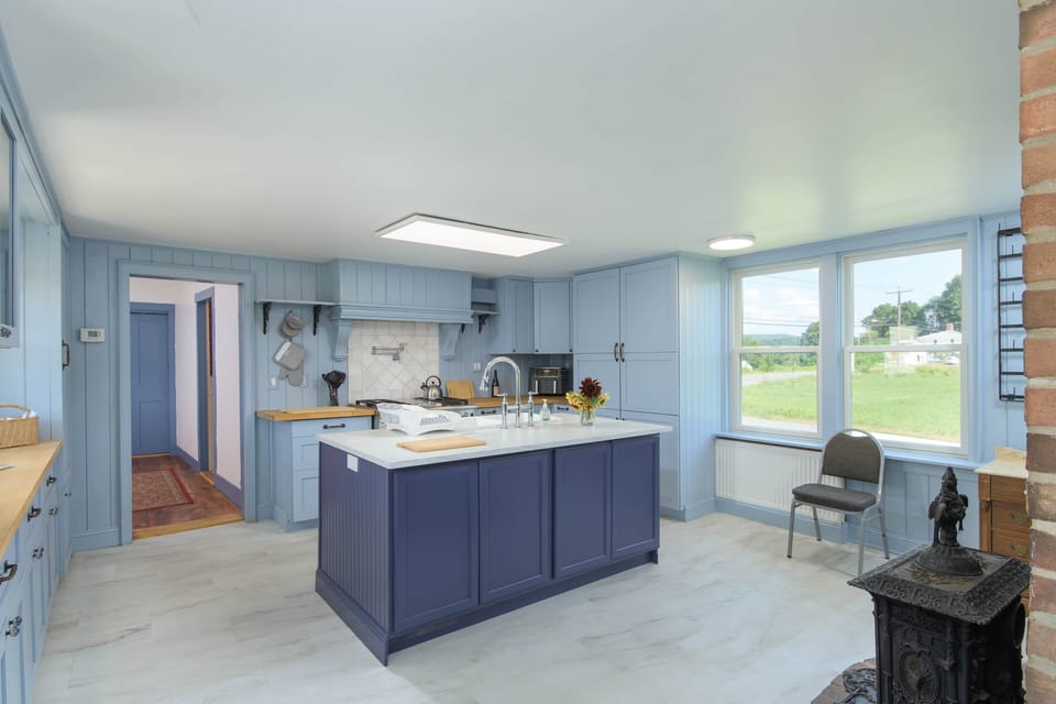 Our chef's kitchen features the refrigerator behind the paneling on the right and a gas range with grill 
