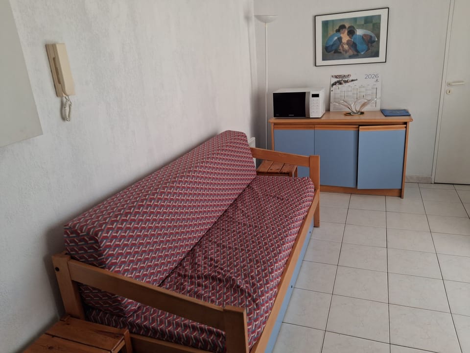 Back from the beach, the living room has a sofa, dining area, and TV — everything you need to wind down